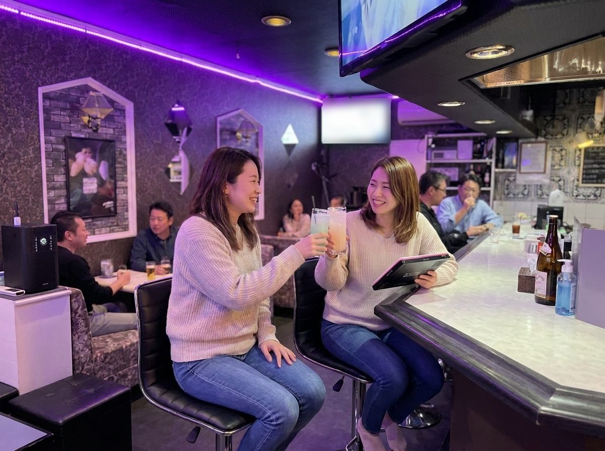 カウンターで乾杯する女性2人（イメージ）